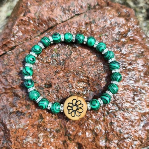 bransoletka damska wykonana z malachitu i drewna oliwnego na którym jest wypalony kwiat. bransoletka jest na gumce, obwód bransoletki 17,4cm mierzony wewnątrz