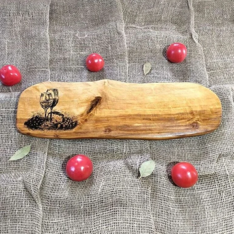 Deska drewniana do podawania serów z drewna jabłoni, po lewej stronie deska ma wypalony wzór, kieliszek wina, ser i winogrona. Wymiary deski 16x53cm
