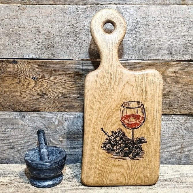 deska do serowania przekąsek wykonana z drewna dębowego. Posiada ozdobny grawer w z winogronami i kieliszkiem czerwonego wina. Wymiary deski 42x19cm