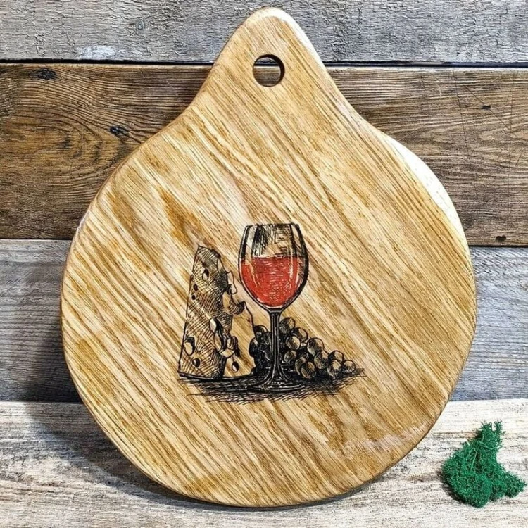 Drewniana deska do podawania przekąsek z wypalonym  wzorem. kieliszek z czerwonym winem, duży kawałek sera i winogrona. Wymiary deski 35x27 cm.