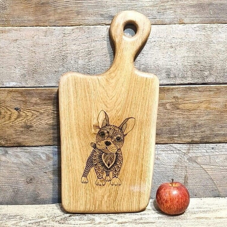 Ręcznie robiona drewniana deska  do serwowania z dębu. Deska jest  nieregularnym kształcie, deska posiada rączkę  i ozdobny grawer buldoga francuskiego.  Rozmiar deski 46x23cm