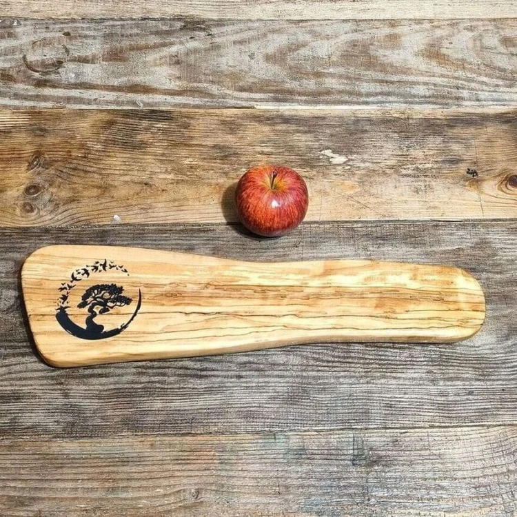 Deska do serwowania przekąsek. Wykonana z drewna oliwnego po lewej stronie deski jest wypalony wzór, drzewko bonsai z ptakami.  Wymiary deski 12x45cm