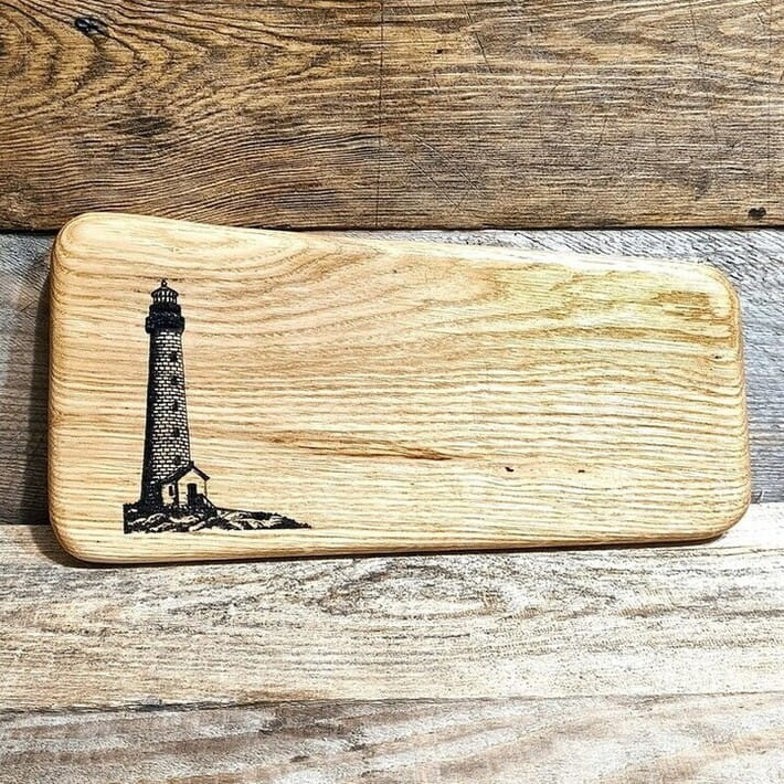 Drewniana deska do krojenia i podawania przekąsek. Deska posiada wypalony ozdobny wzór latarnia morska.  Wymiary deski - 16x33 cm