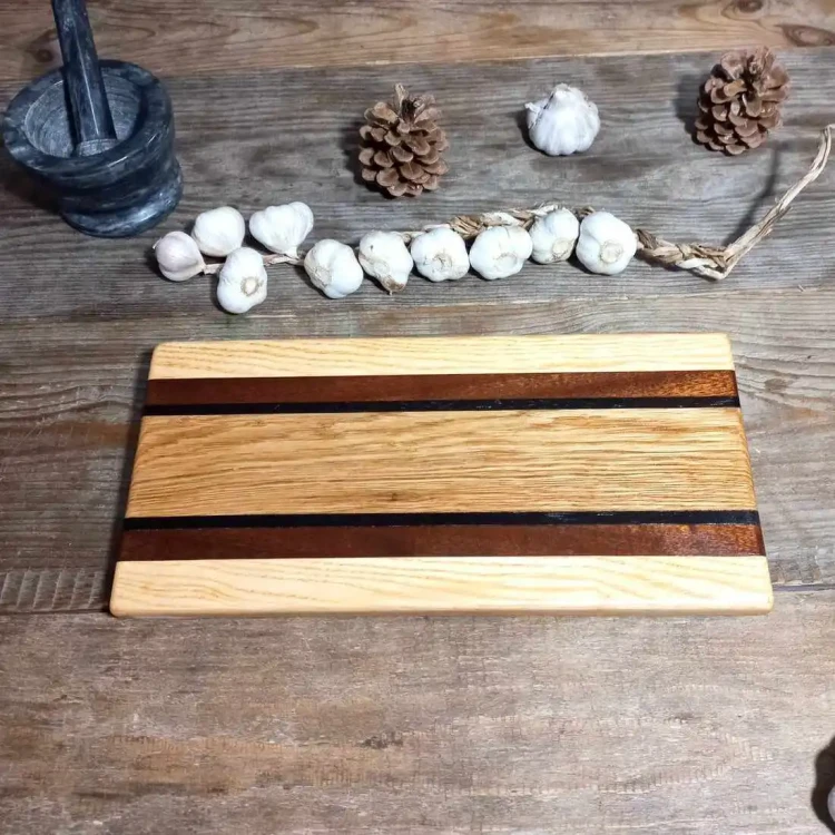 Ręcznie robiona deska do krojenia i serwowania przekąsek Nela Wood wykonana z połączenia drewna dębowego, mahoniowego, jesionowego i wenge.