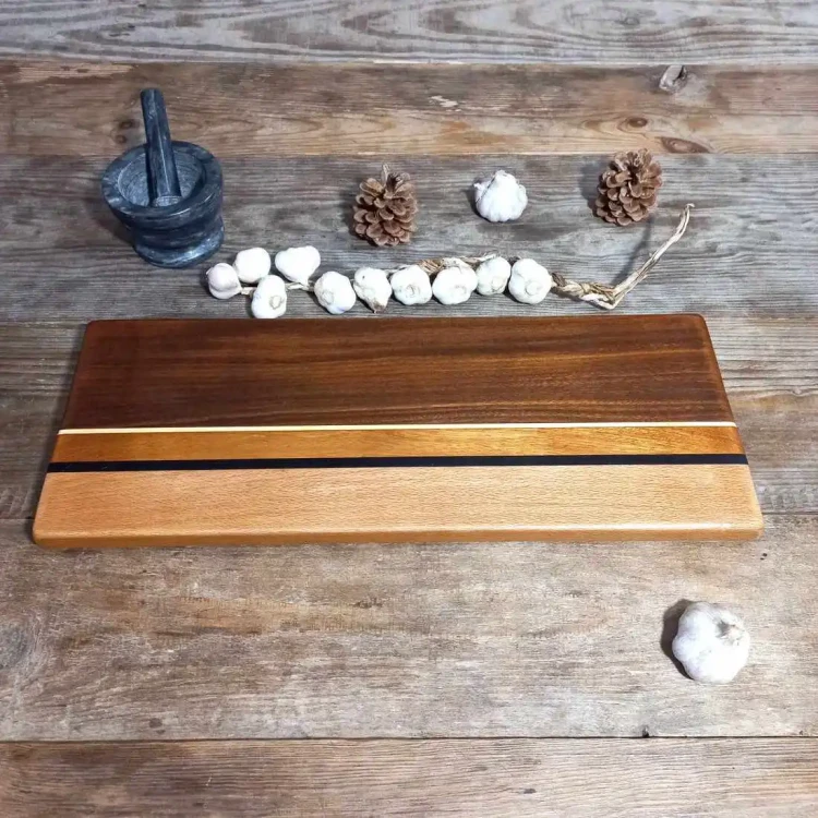 Ekskluzywna, ręcznie robiona deska do serwowania i krojenia z mozaiki drewna bukowego, mahoniowego i iroko od Nela Wood. Wymiary deski 19x50cm