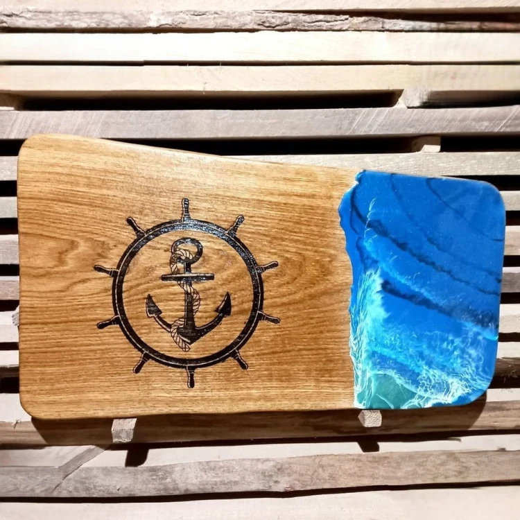 Deska do serwowania dębowa
Z wypalonym kołem sterowym, kotwica  i żywicą imitującą fale morskie
wymiary deski 36x62cm