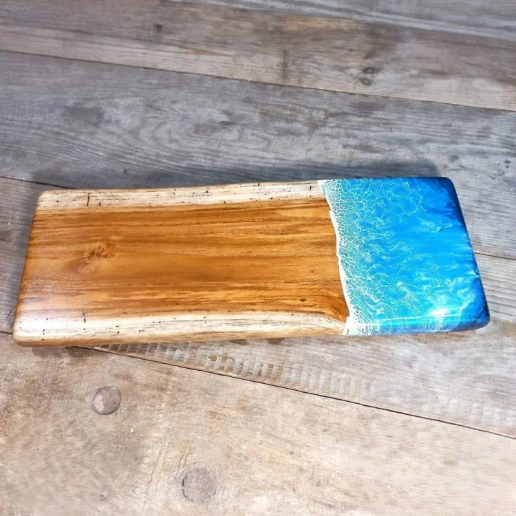Deska drewniana do podawania serów z drewna tekowego
z żywicą imitującą falę morską po prawej stronie
wymiary 17x44cm
