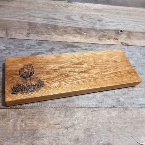 deska drewniana do krojenia i podawania przystawek
po lewej stronie deski jest wypalony wzór, dwa kieliszki z winem i winogrona
wymiary deski 22x59cm
