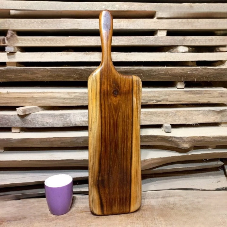 Deska drewniana krojenia z drewna teakowego. 
w części środkowej deska jest ciemna, po bokach posiada biel 
deska ma rączkę
Wymiary deski 58 x 15 cm