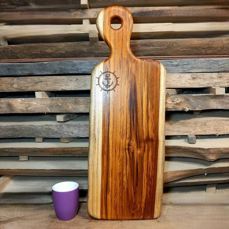 deska do krojenia i podawania przekąsek 
posiada wypalone koło sterowe wraz w kotwicą 
deska ma rączkę 
wymiary 62x22cm