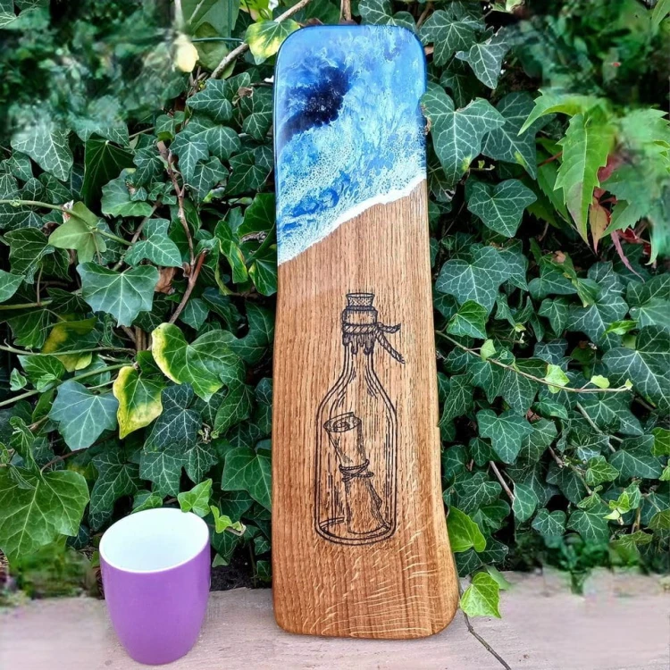 Deska do podawania serów,  dębowa, z żywicą imitującą falę morską,  wypalony na stałe wzór - list w butelce
deska ma rączkę 
wymiary 48x15cm