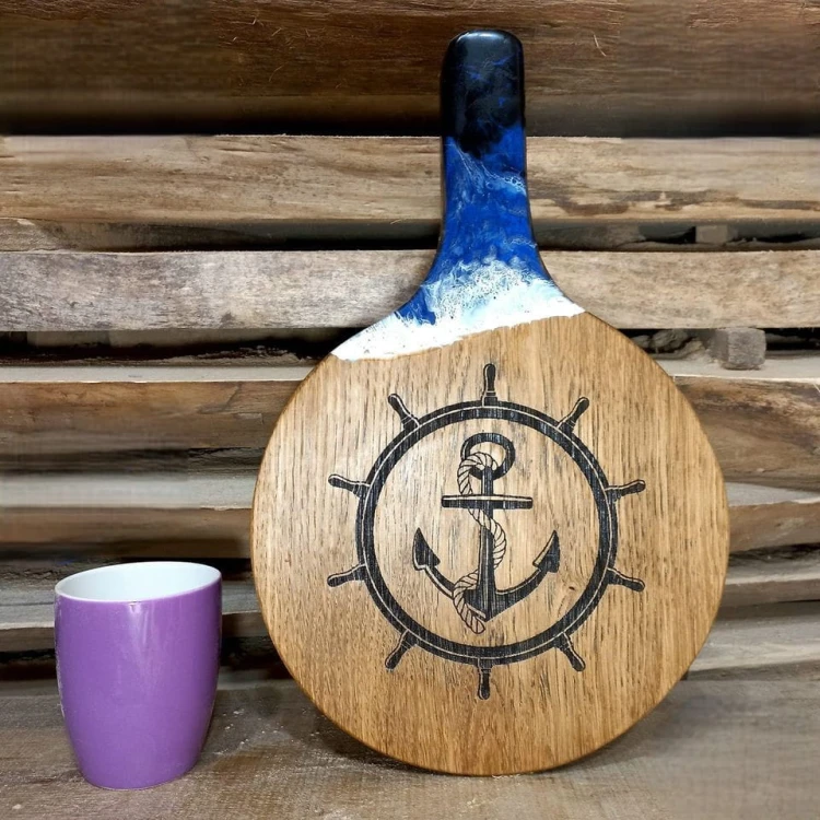 Deska do podawania serów,  dębowa, z żywicą imitującą falę morską,  wypalony na stałe wzór - koło sterowe i kotwicę 
deska ma rączkę 
wymiary deski 37x24cm