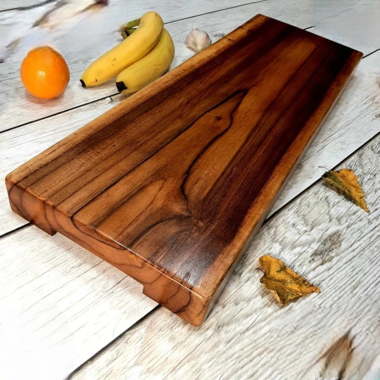 deska do krojenia, wykonana z drewna tekowego
po obu stronach od dołu ma podcięcia aby ułatwić chwytanie 
wymiary deski 64x22x4,7cm