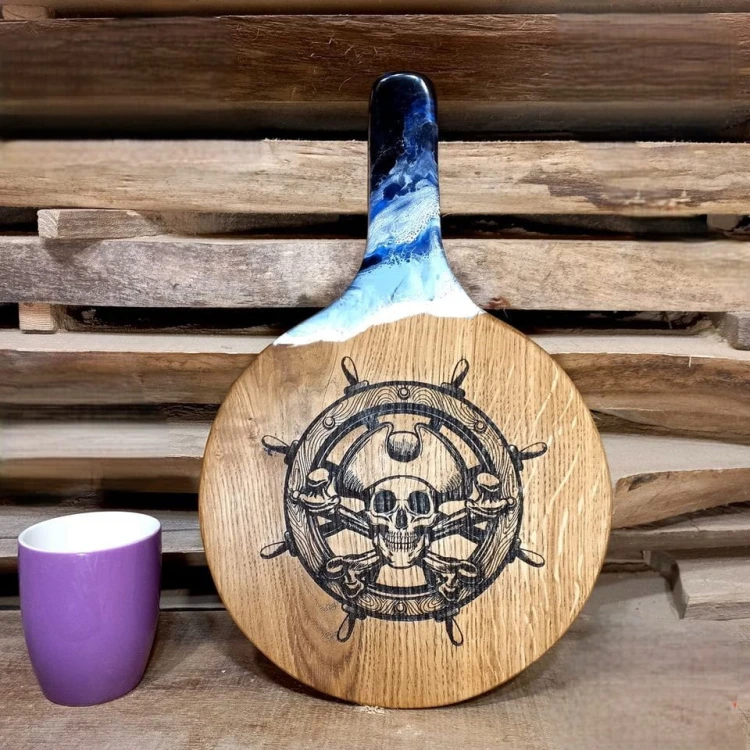 Deska do podawania serów,  dębowa, z żywicą imitującą falę morską,  wypalony na stałe wzór - koło sterowe i  pirat
deska ma rączkę 
wymiary deski 37x24cm