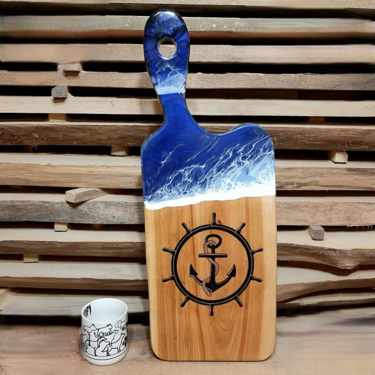 Deska do podawania serów,  czereśniowa, z żywicą imitującą falę morską,  wypalony na stałe wzór - koło sterowe i kotwicę 
deska ma rączkę 
wymiary deski 62x24cm