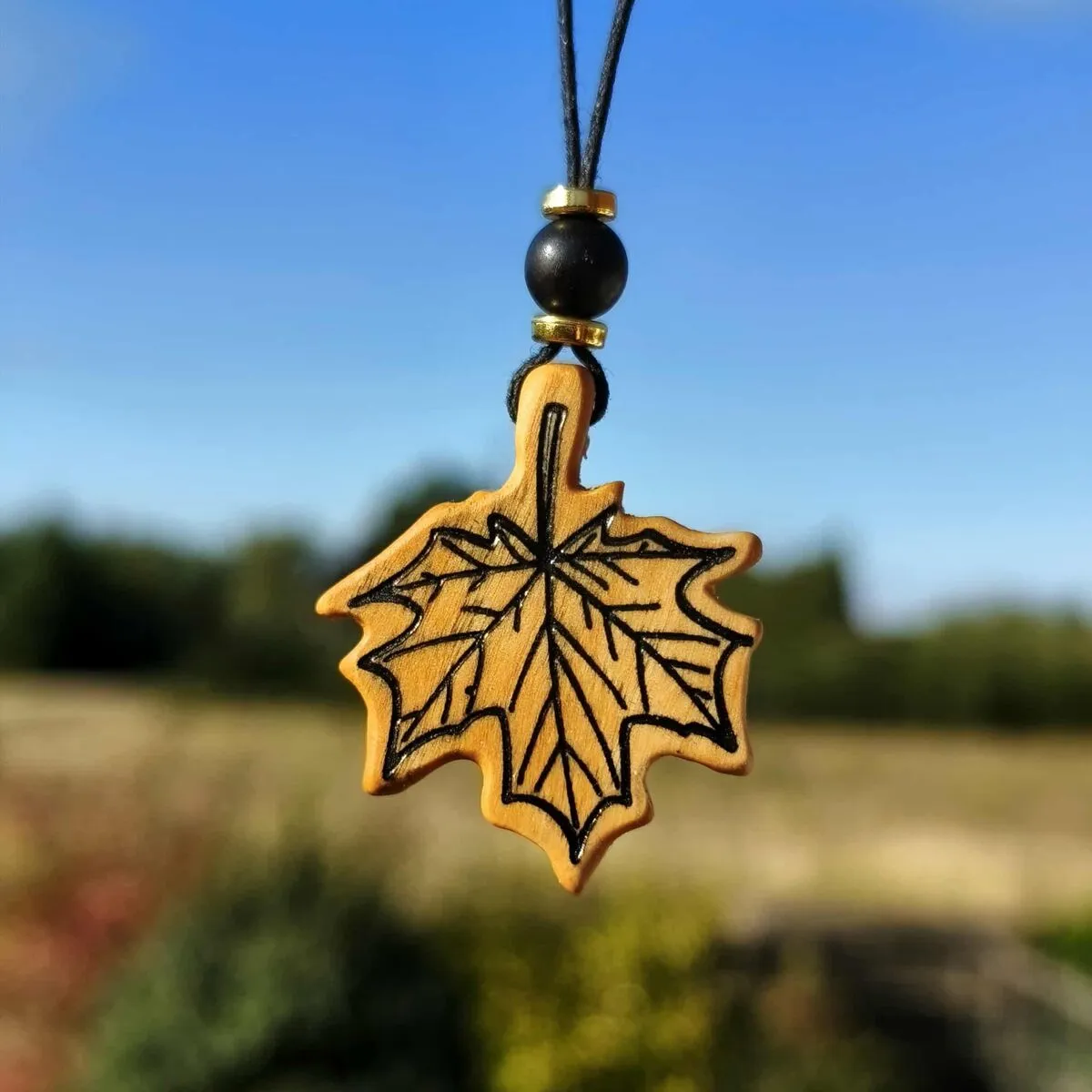 Damski wisiorek handmade z drewna oliwnego w kształcie liścia klonu - unikalna biżuteria od Nela Wood