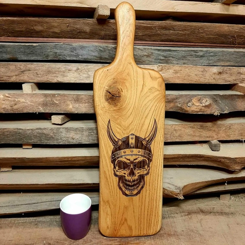 Personalizowana deska dębowa Nela Wood z grawerem czaszki wikinga. Szlachetne drewno: iroko, meranti, zebrano.