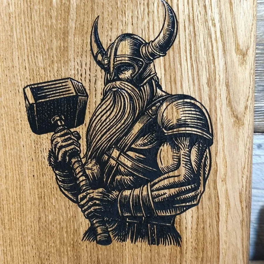 Detal graweru laserowego Wiking i Młot Thora na desce dębowej Nela Wood