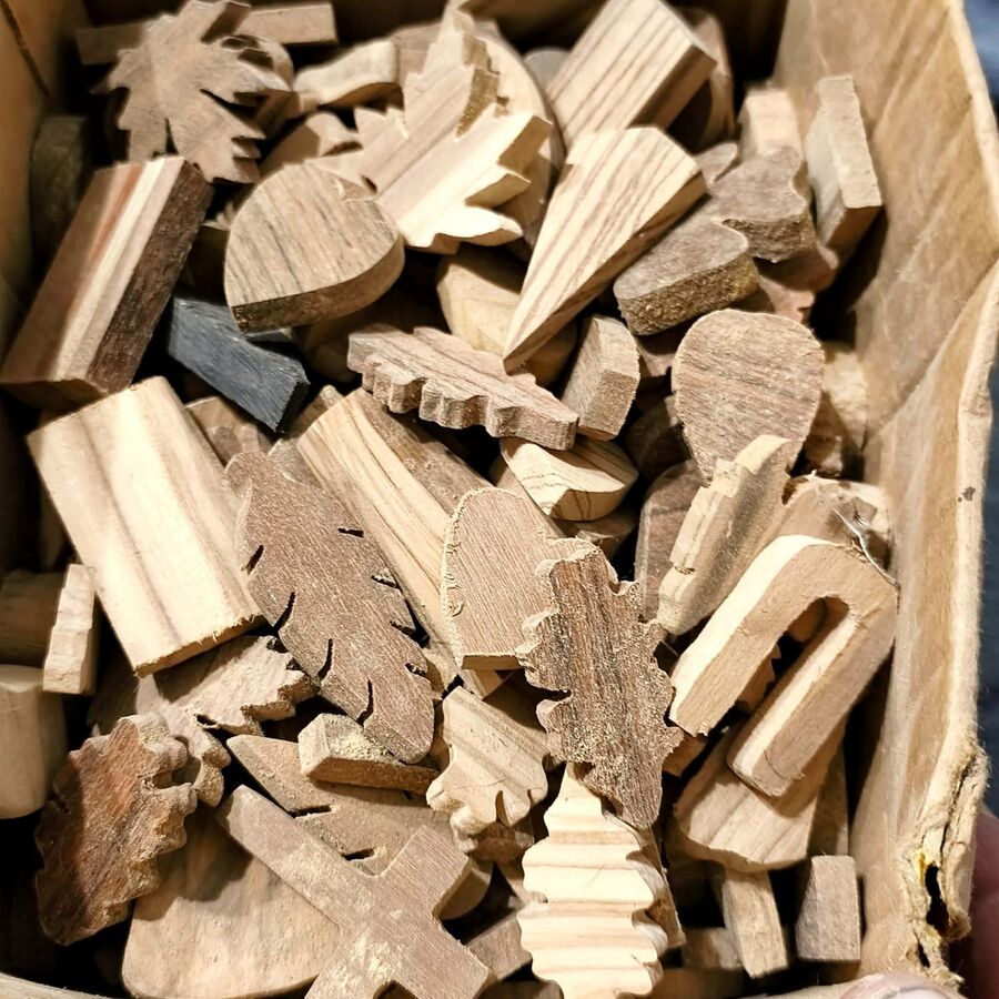 Wstępnie docięte kształty wisiorków z drewna egzotycznego na stole warsztatowym