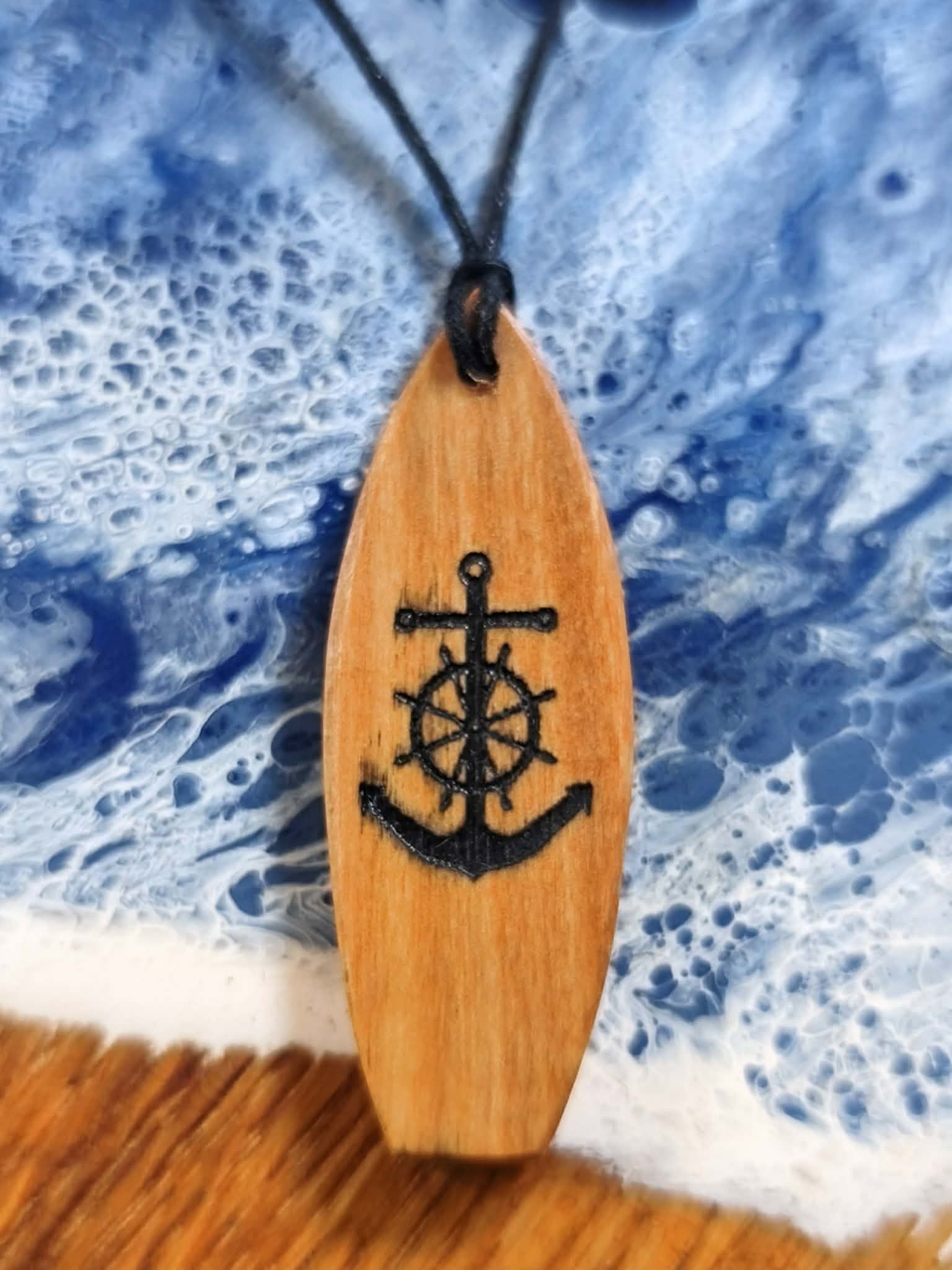Artystyczny wisiorek z drewna oliwnego w kształcie deski surfingowej z wypalonym motywem kotwicy od Nela Wood