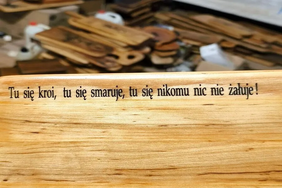 Głęboki grawer laserowy na drewnie z napisem Tu się kroi tu się smaruje - personalizowane prezenty Nela Wood