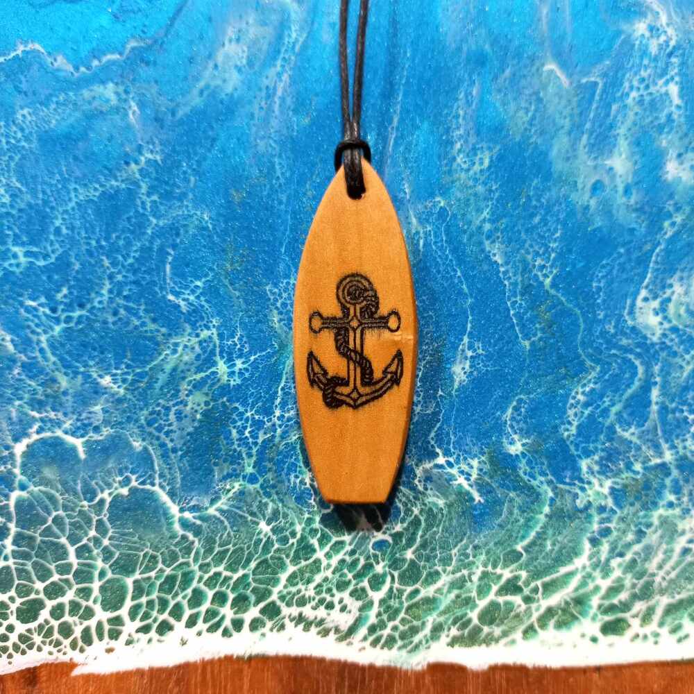 Surferski wisiorek z kotwicą wykonany z drewna oliwnego przez Nela Wood