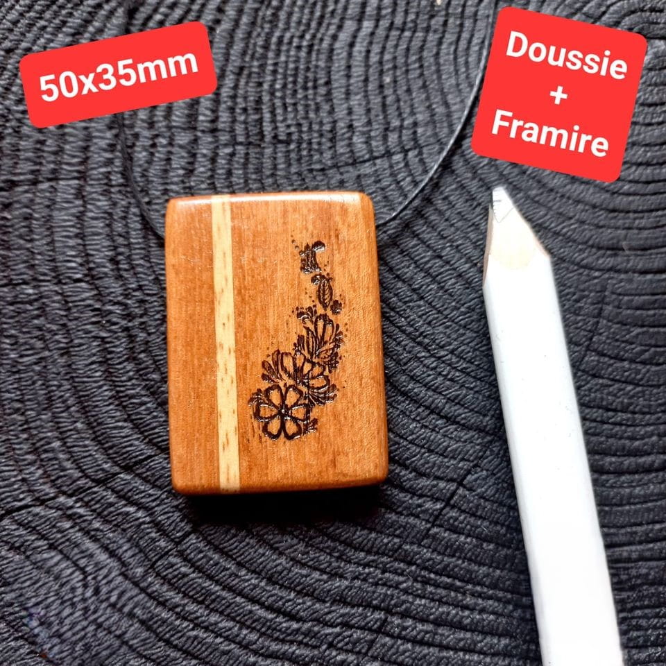 Ręcznie robiony wisiorek damski z egzotycznego drewna Daussie i Framire, o eleganckim, grawerowanym motywie, zawieszony na regulowanym bawełnianym sznurku.